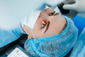 Woman in blue surgical gown looking at camera, showcasing LASIK technology advancements.