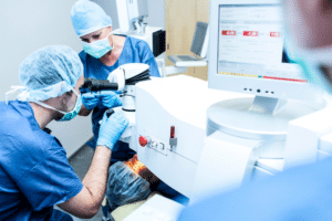 A team in blue scrubs demonstrating how LASIK works.