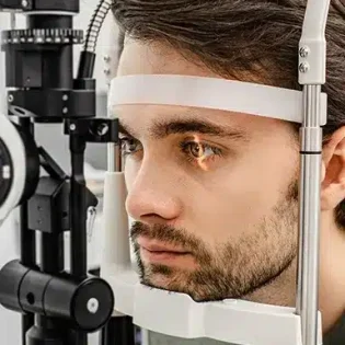 Glaucoma: A bearded male with dark brown hair rests his head in an examination device.